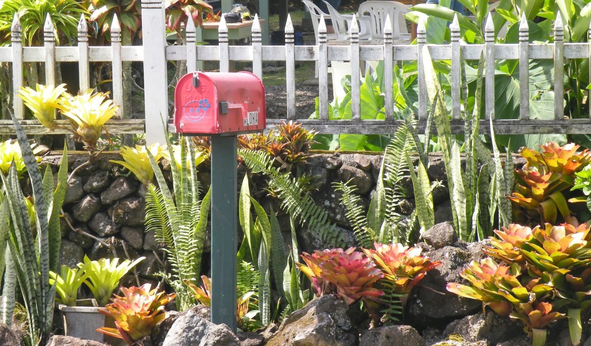 Garden outside a white picket fence with a red mailbox on the island of Maui, Hawaii