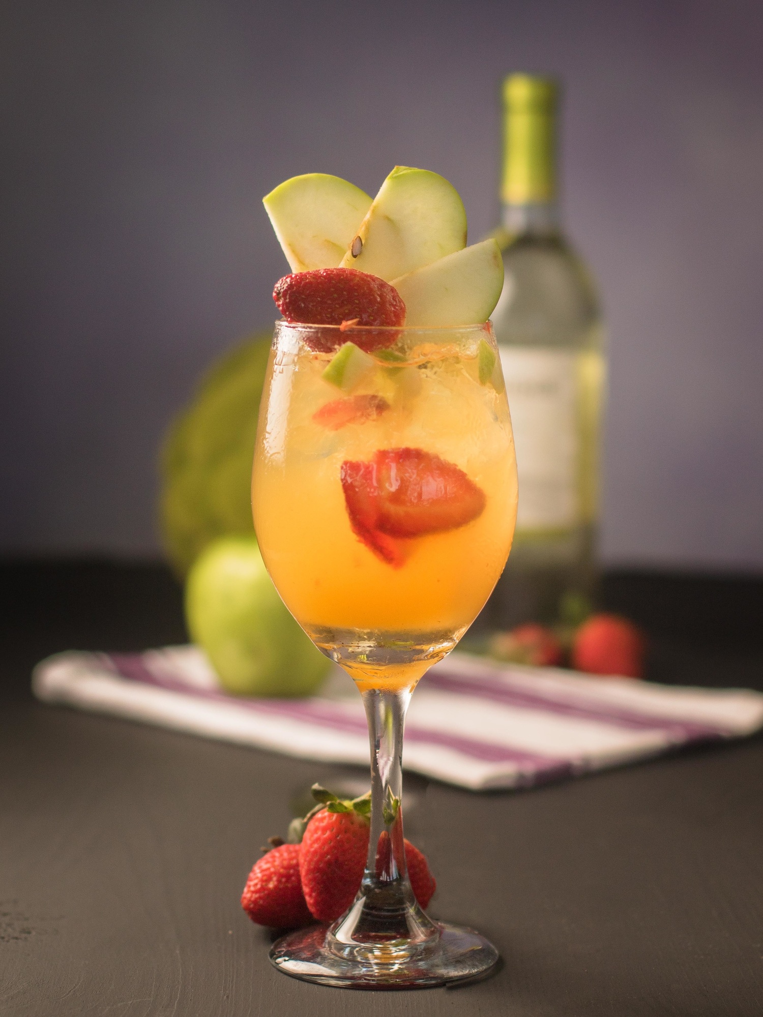 Closeup of lemon sangria cocktail with strawberry and apple