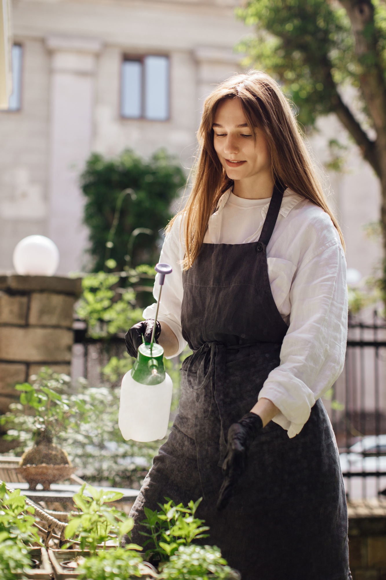 Woman florist watering plants in a flower shop - stock photo.