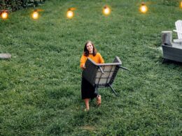 Woman relocating a chair from the garden patio, String lights, Cozy Backyard