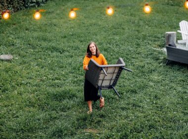 Woman relocating a chair from the garden patio, String lights, Cozy Backyard