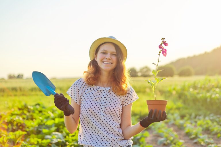 Young teenager girl in gloves walking with garden trowel and pot flower