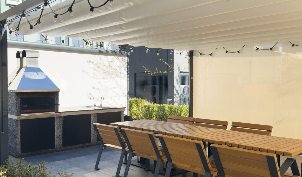 A spacious barbecue area with a canopy made from natural materials, enclosed. A patio with a table