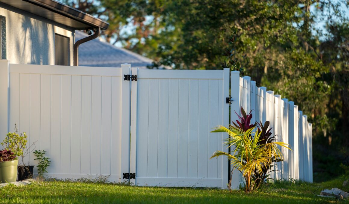 White vinyl picket fence on green lawn surrounding property grounds