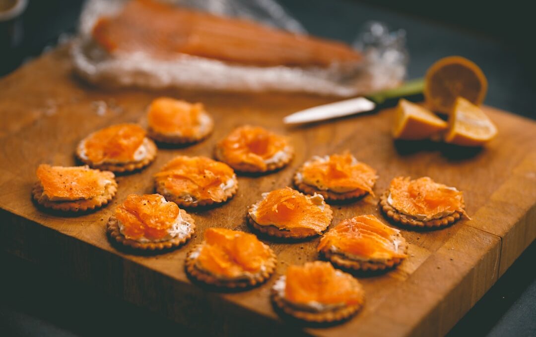 a wooden cutting board topped with small crackers