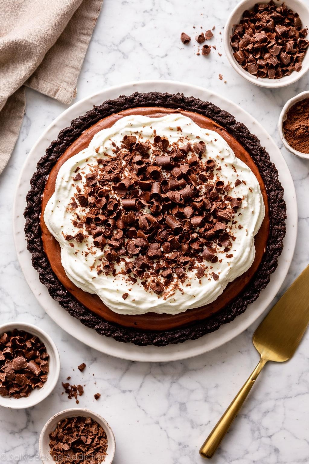 An overheard picture view of a plate of Chocolate Cream Pie sitting on a marble countertop table in the kitchen, professional food photography style.