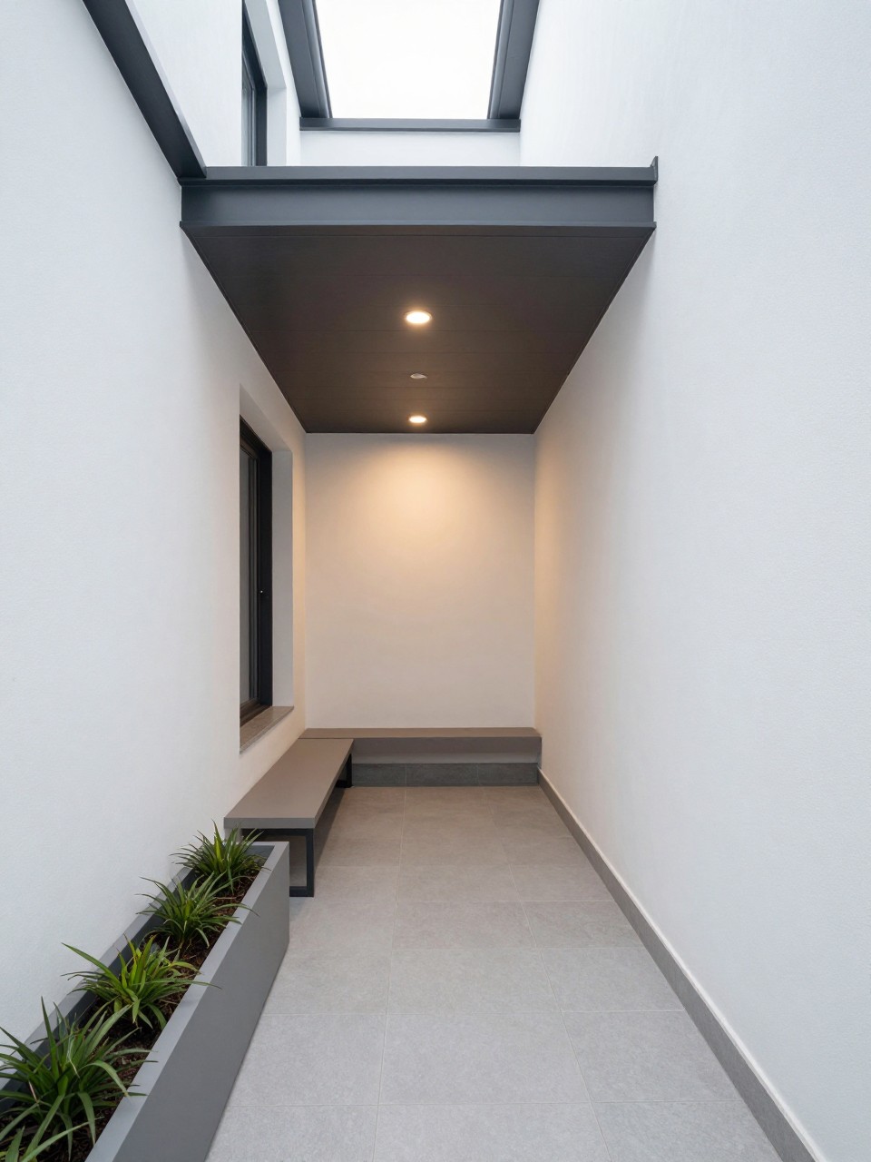 Image Prompt: A narrow modern side patio with a slim roof extension attached to the house, small outdoor bench, long planter boxes, light gray tile floor, soft wall lighting, clean white exterior wall, compact stylish outdoor corridor design, no people, realistic DSLR photo, no text, no watermarks on images.