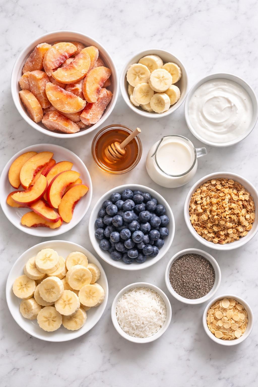 Prompt: A realistic top-down flat lay food photography image of peach smoothie bowl ingredients arranged neatly on a countertop marble table. Include frozen peach slices, frozen banana slices, thick Greek yogurt, almond milk, honey, fresh peach slices, fresh banana slices, blueberries, granola, chia seeds, shredded coconut, and almond flakes. Clean bright natural light, simple organized layout, no people, no hands, no text, no watermarks, no props with writing.